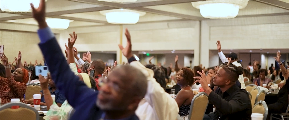 Convention attendees with hands raised in celebration